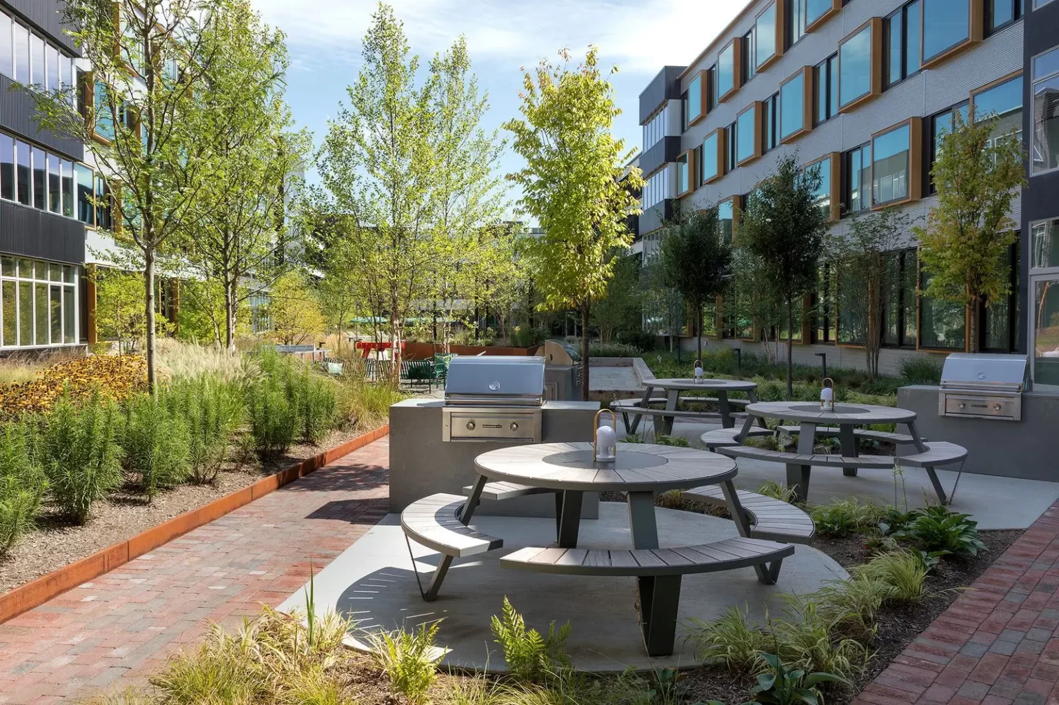 Pantagruel placed as a gigantic picnic table near to fire pits and BBQ grills for shared dining experiences.